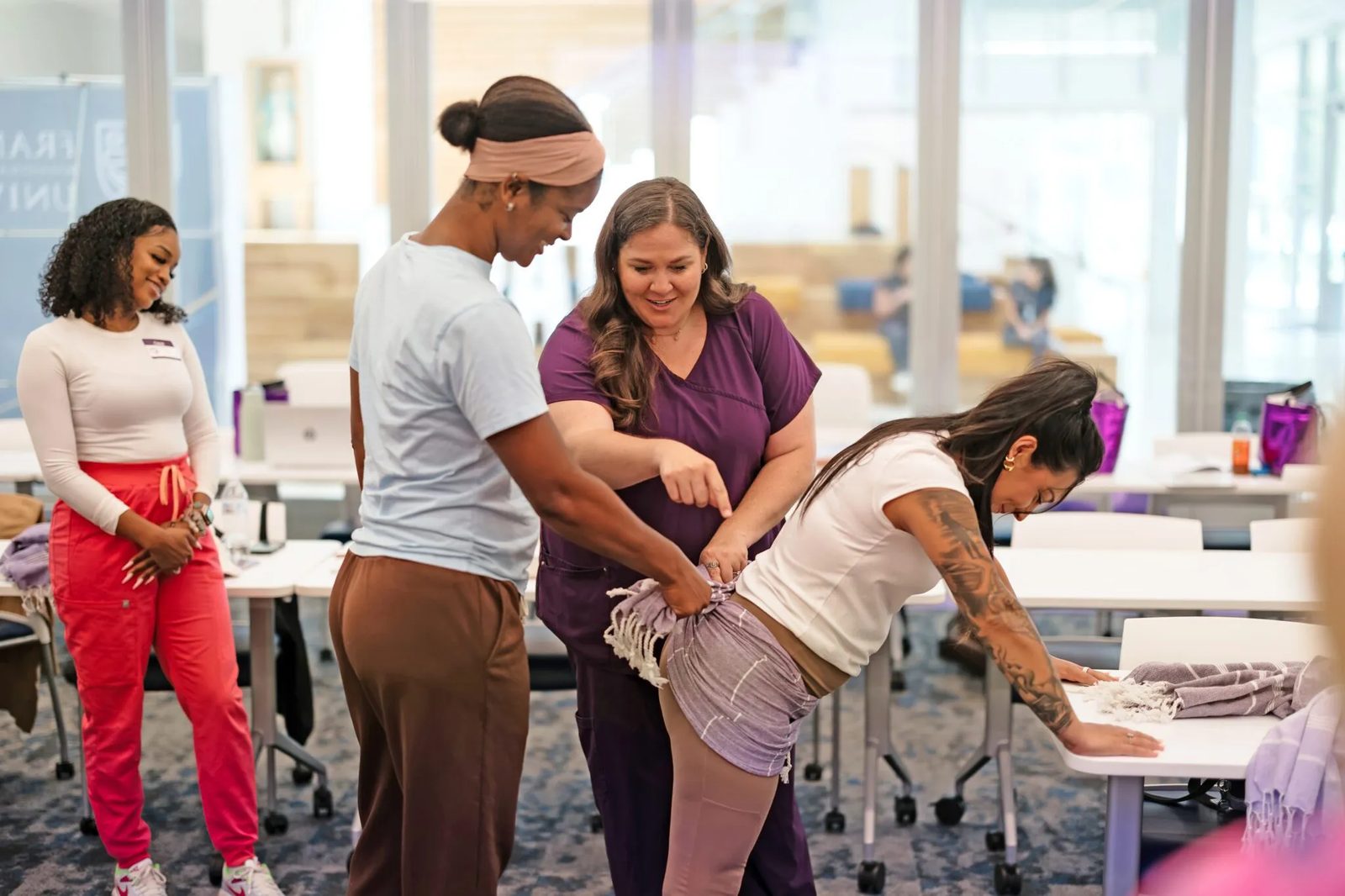 Madeline Harris LeBlanc teaching a hands-on rebozo technique to doula students during a training at Franciscan Missionaries of Our Lady University