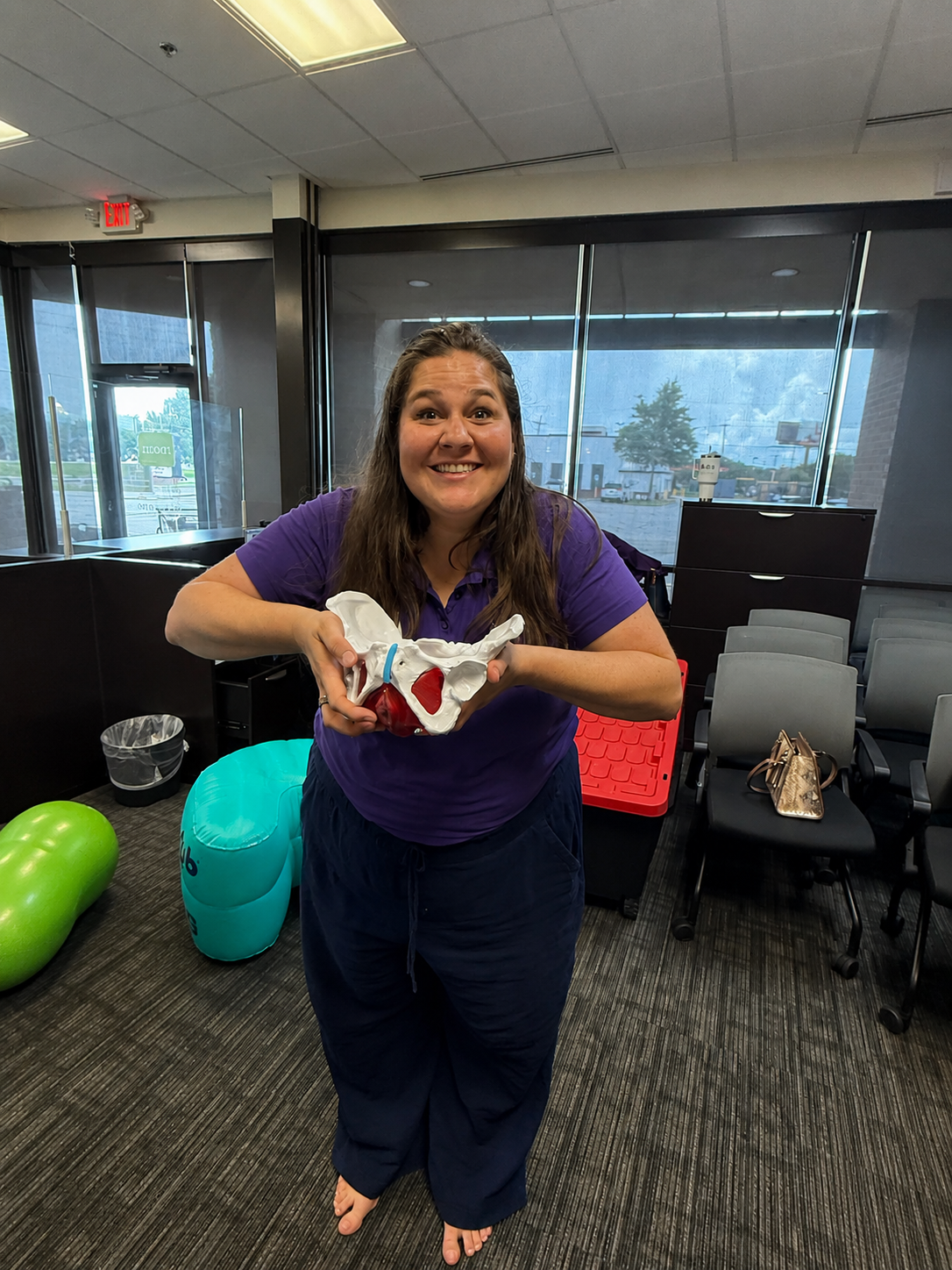 Maddy in the training room teaching anatomy with a pelvic model